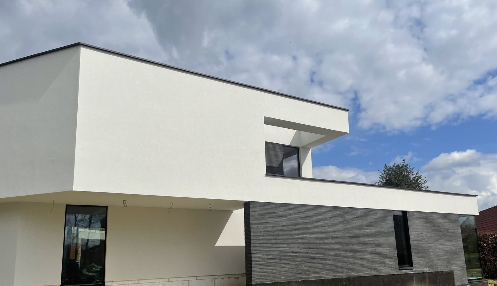 Witte crepigevel met steenstrips in Gingelom