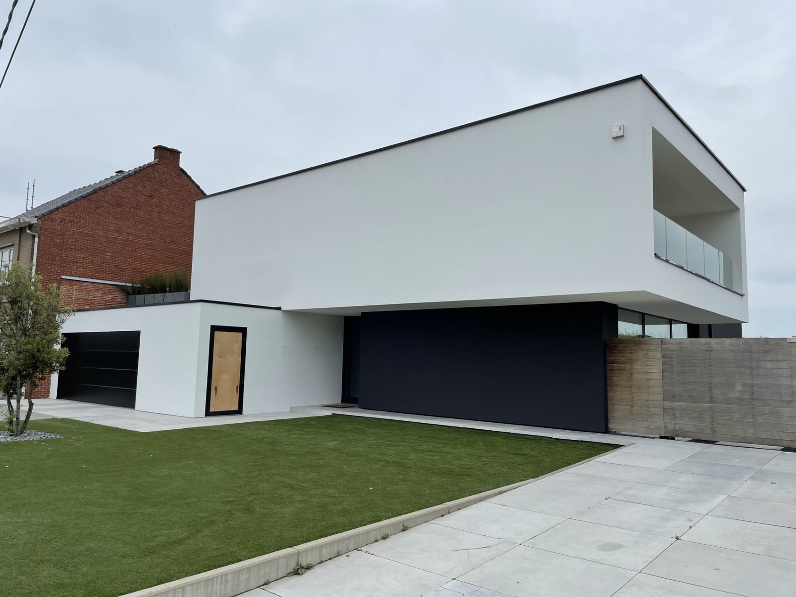 Moderne witte woning met nieuwe gevelpleister en groen gazon